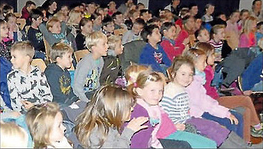 Eine Gruppe von Kindern sitzt eng beieinander in einem Raum, vermutlich bei einer Veranstaltung von VIDETO, die demokratische Werte und ein respektvolles Miteinander fördert.