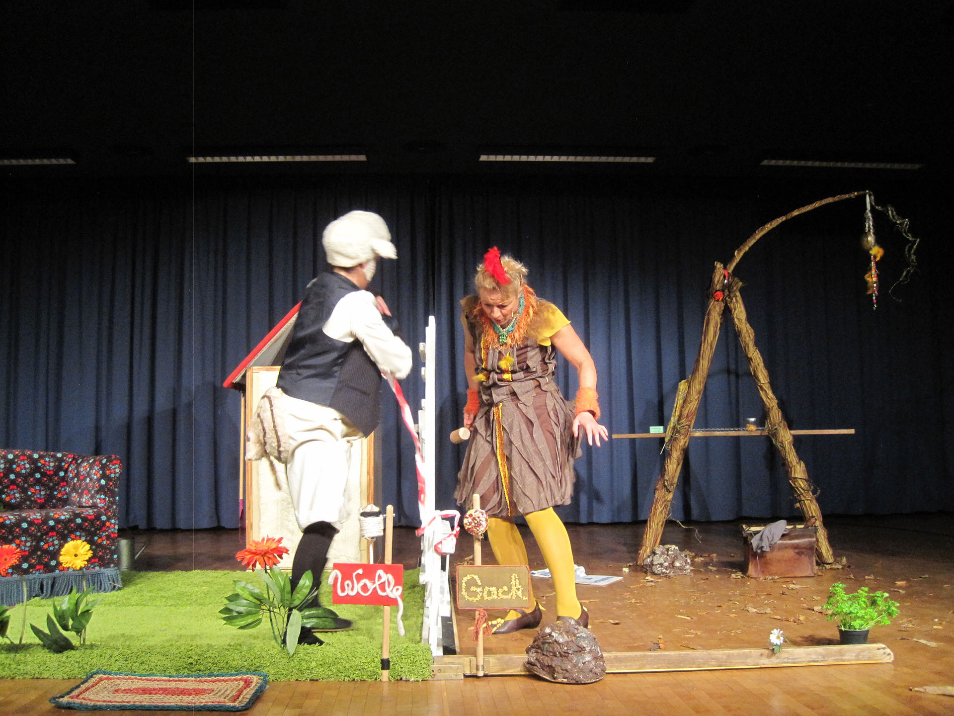 Zwei Schauspieler in Kostümen (einer als Bauer, eine als Huhn 