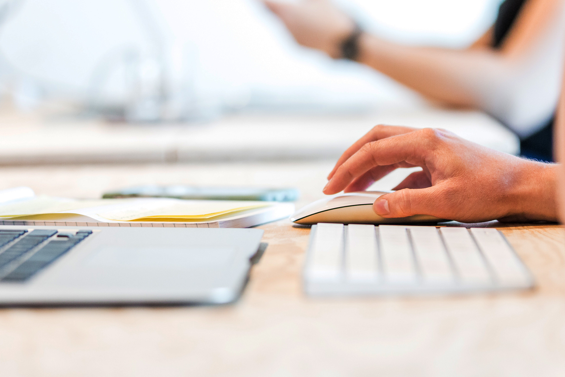 Ein Arbeitsplatz mit Laptop, Tastatur, Maus und Papieren, an dem jemand aktiv am Computer arbeitet, symbolisierend für das Engagement in Projekten zur Förderung von Demokratie, Vielfalt und einem respektvollen Miteinander.